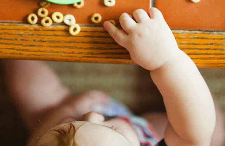 Arial picture of a child eating Cheerios off a countertop.