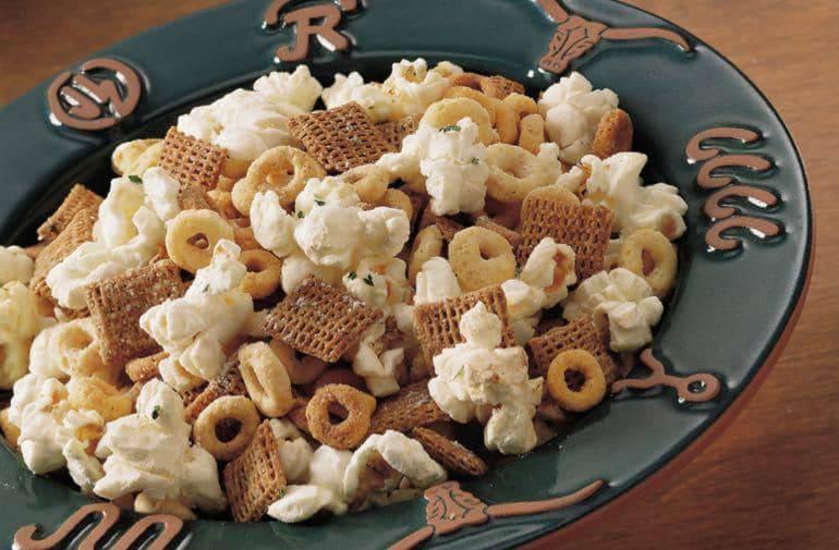 Cheerios CA, Chex, and popcorn snack mix in a bowl